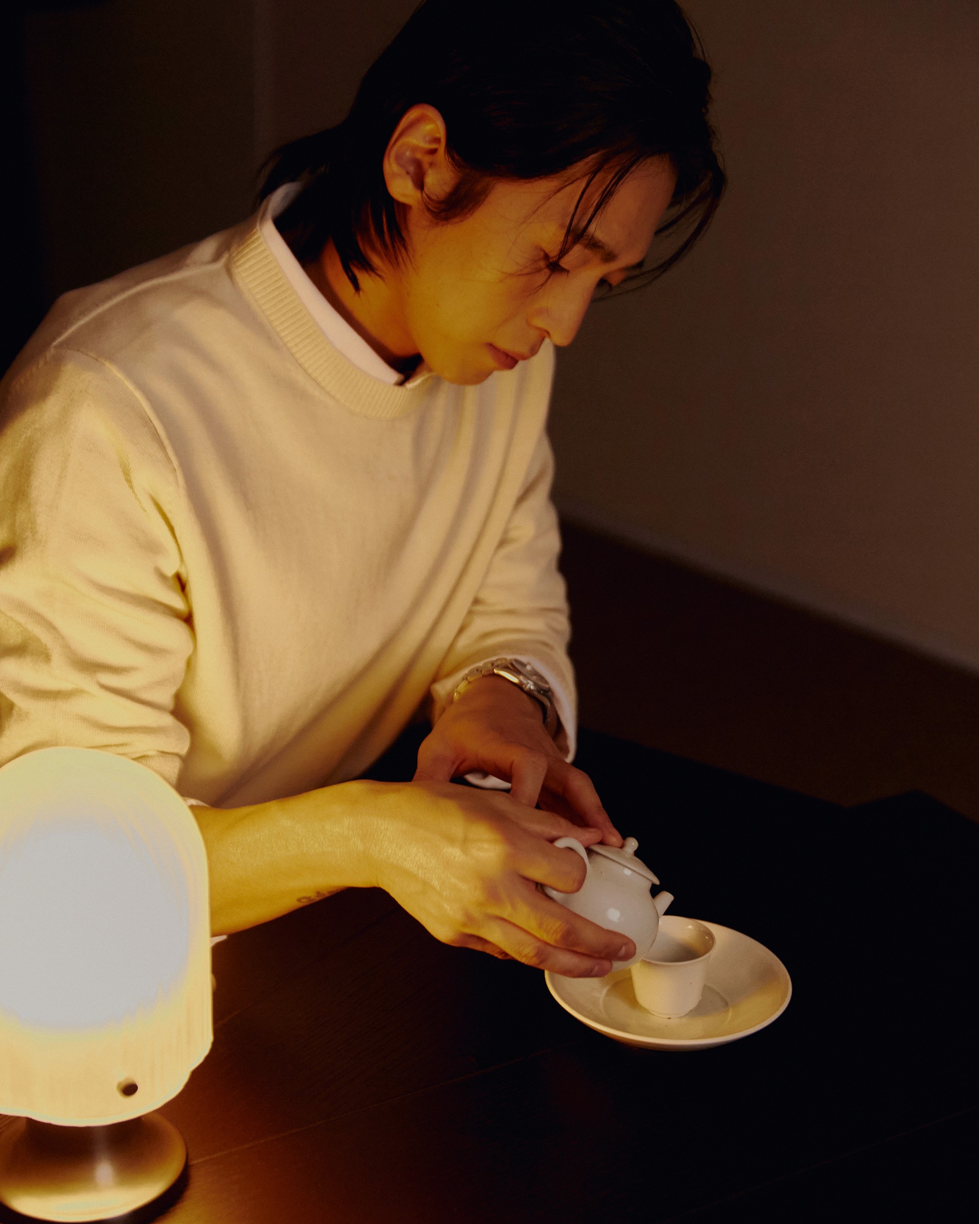 Tea being poured under warm light in the PLAYA Audio Lounge