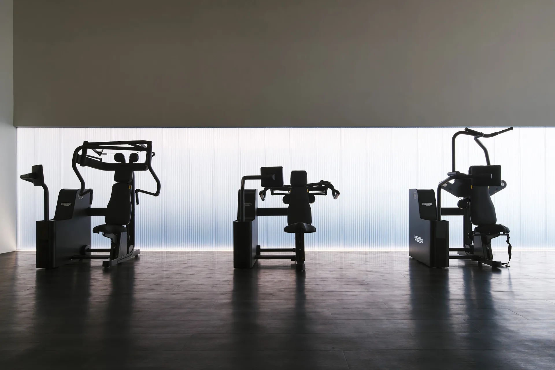 PLAYA fitness machines arranged beneath calm architectural lighting